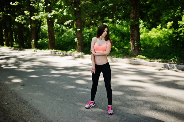 Fitness fille sportive en vêtements de sport faire de l'exercice dans la route au parc , — Photo