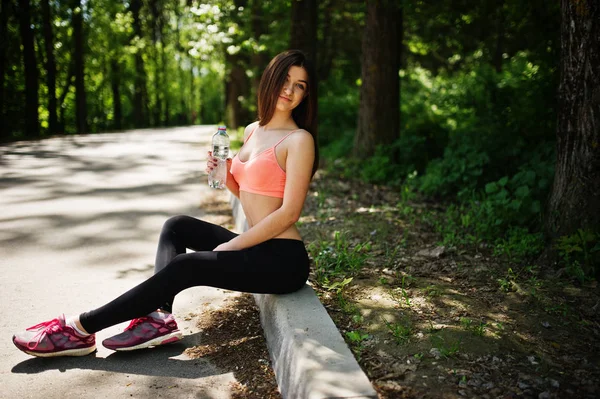 Chica de deporte de fitness en ropa deportiva sentado en la carretera en el parque con wa — Foto de Stock