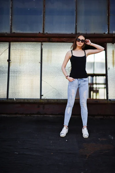 Mädchen mit Sonnenbrille und Jeans posierte auf dem Dach der abadoned indus — Stockfoto