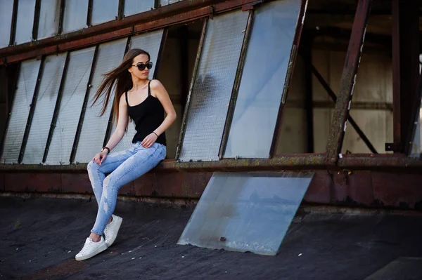 Mädchen mit Sonnenbrille und Jeans posierte auf dem Dach der abadoned indus — Stockfoto