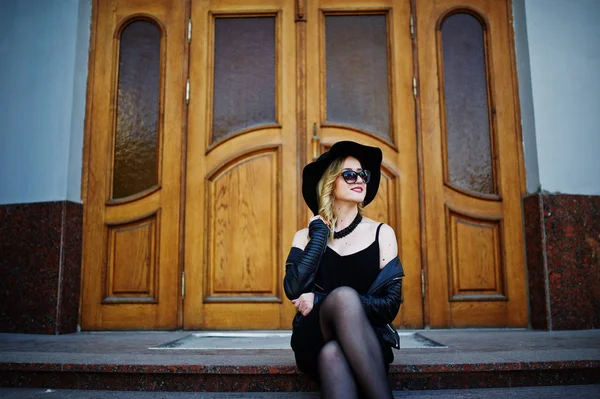 Blonde woman on black dress, leather jacket, sunglasses, necklac — Stock Photo, Image