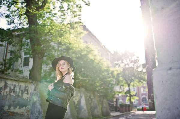 Blonde Frau in schwarzem Kleid, Lederjacke, Halsketten und Hut — Stockfoto