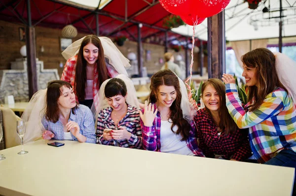 のテーブルに座って格子縞のシャツで陽気な女の子のグループ — ストック写真