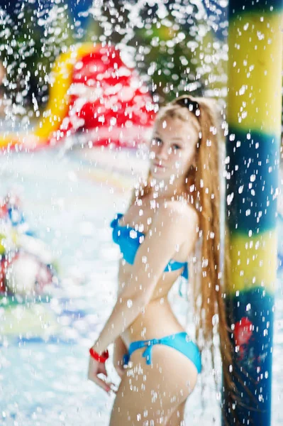 Porträtt av en vacker flicka som bär blå bikini i en pool posin — Stockfoto
