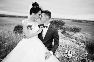 Güzel gelin ve yakışıklı damat taş ile oturuyor