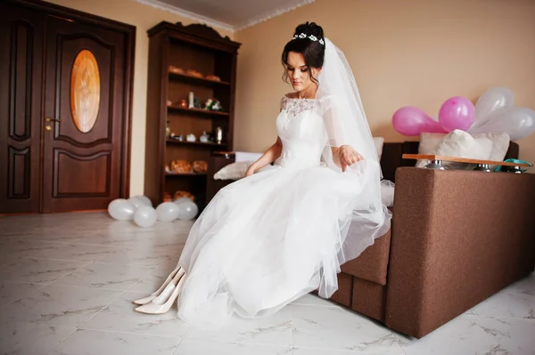 Bonita noiva vestindo elegantes sapatos de casamento branco em seu quarto . — Fotografia de Stock