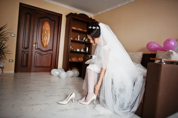 彼女の部屋で白のエレガントな結婚式の靴を履いてかなりの花嫁. — ストック写真