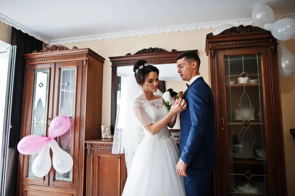 Splendida sposa mette un fiore asola sulla giacca di uno sposo . — Foto Stock