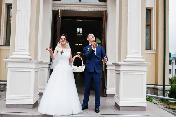 Schönes Hochzeitspaar beim Verlassen der Kirche. Brautjungfer — Stockfoto