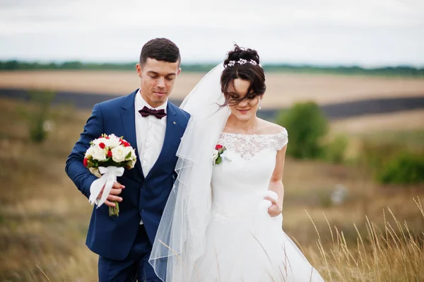 Couple de mariage fantastique marchant dans l'herbe haute avec le pin — Photo