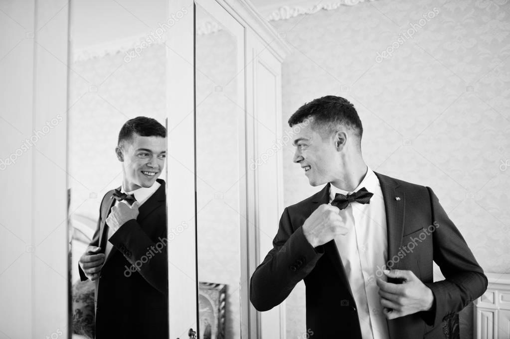 Handsome groom dressing up and getting ready for his wedding in 