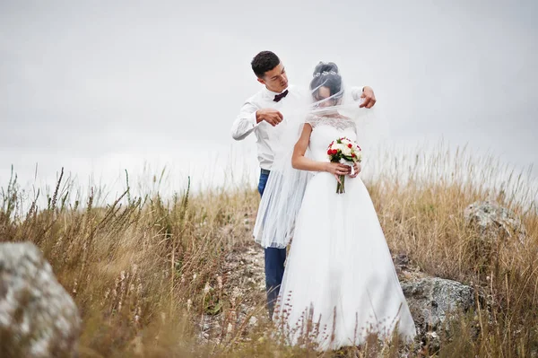 Fantástica pareja de boda caminando en la hierba alta con el pino —  Fotos de Stock