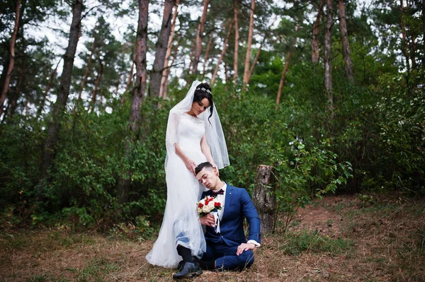 Makellose Braut im Stehen und ihr Mann, der neben ihr im T sitzt — Stockfoto