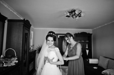 Gelinin nedimesi gelinlik üzerinde bir kurdele bağlamak için yardım. Siyah ve