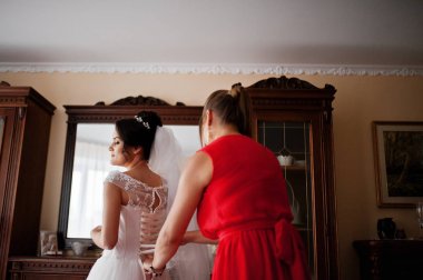 Nedime gelinlikle bir spaci üzerinde bir kurdele bağlamak için yardım