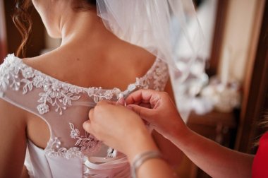 Nedime gelinlikle bir spaci üzerinde bir kurdele bağlamak için yardım