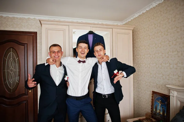 Handsome groom and groomsman in the room hugging next to the mir — Stock Photo, Image