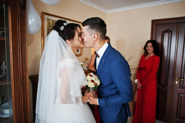 Matrimonio coppia baci in camera con damigelle d'onore nel backg — Foto Stock
