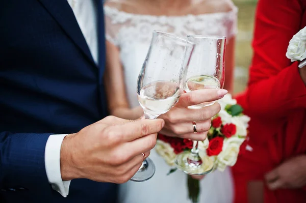 Novio guapo y hermosa novia tintineo gafas de boda lleno — Foto de Stock