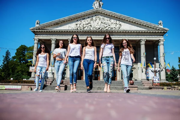 Seis chicas fantásticas caminando por la calle con un majestuoso buildi —  Fotos de Stock