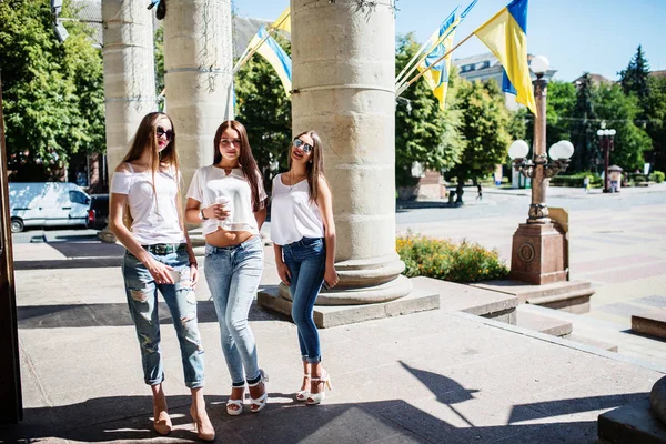 Τρία πανέμορφα κορίτσια στέκεται από τις στήλες σε μια ηλιόλουστη ημέρα. — Φωτογραφία Αρχείου