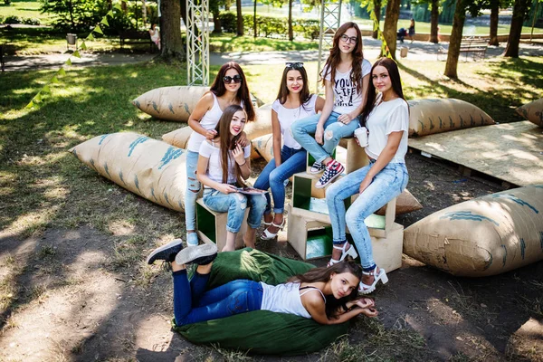 Seis niñas felices divirtiéndose en almohadas gigantes en el parque . — Foto de Stock