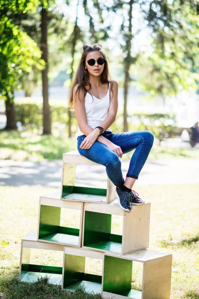 Portret van een modieus gekleed meisje poseren op houten kisten in — Stockfoto