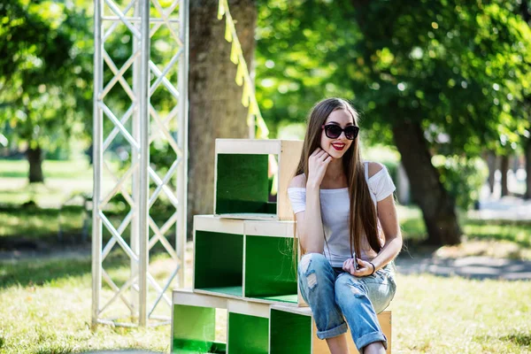 Retrato de una chica vestida a la moda posando en cajas de madera en — Foto de Stock