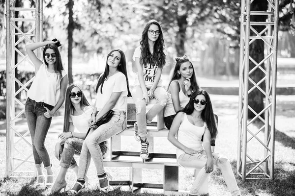 Шесть прекрасных девушек-моделей позируют на деревянных коробках в парке — стоковое фото