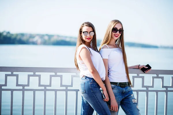 B bir göl ile güneş gözlüğü takıyor iki güzel kız poz — Stok fotoğraf