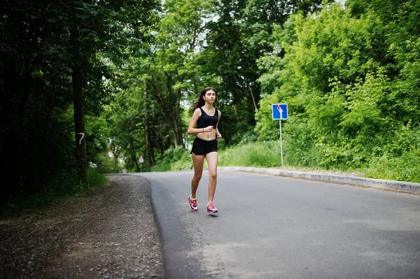 Esporte menina em sportswear correr em um parque verde e treinamento em — Fotografia de Stock