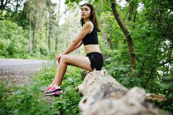 Deportiva en ropa deportiva descansando en un parque verde después del tren — Foto de Stock