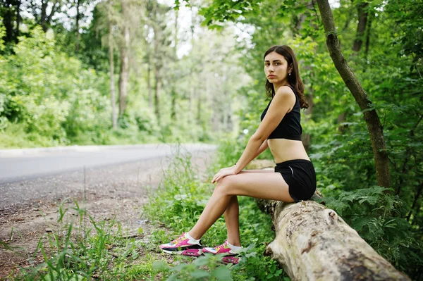 Deportiva en ropa deportiva descansando en un parque verde después del tren — Foto de Stock