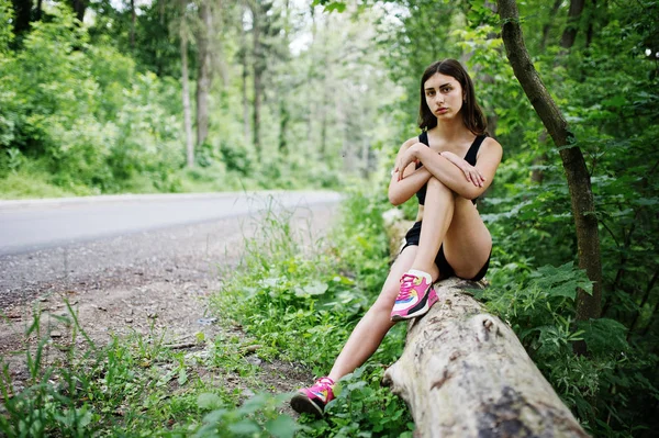 Deportiva en ropa deportiva descansando en un parque verde después del tren — Foto de Stock