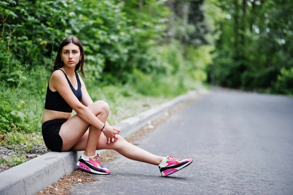 Sport girl at sportswear having rest in a green park after train — Stock Photo, Image