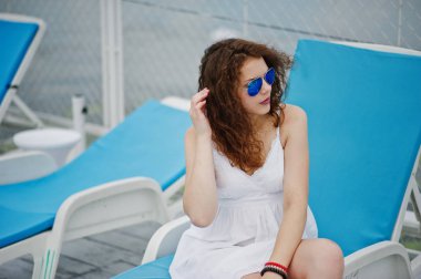 Giyen bir tembel oturan muhteşem bir genç kadın portresi 