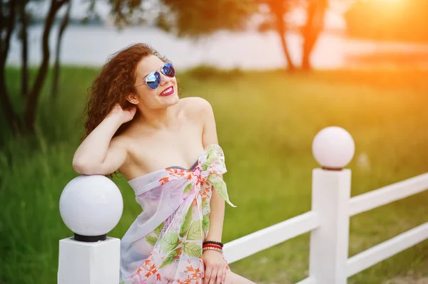 Retrato de um belo modelo posando contra a cerca em sungla — Fotografia de Stock