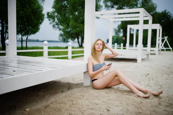 Retrato de una hermosa joven en bikini sentada al lado de la —  Fotos de Stock