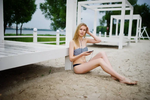 Portréja egy gyönyörű fiatal lány bikini ül a — Stock Fotó