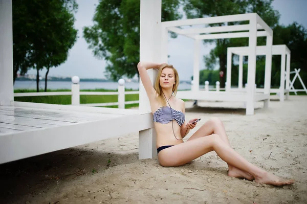 Portréja egy gyönyörű fiatal lány bikini ül a — Stock Fotó