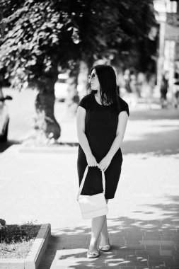 Güneş gözlüğü ile el çantası el altında siyah elbiseyi, esmer kız 