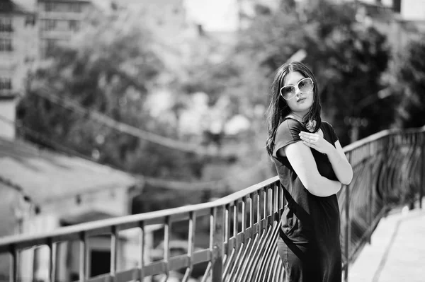 Chica morena en vestido negro, gafas de sol posando en la calle de cit —  Fotos de Stock