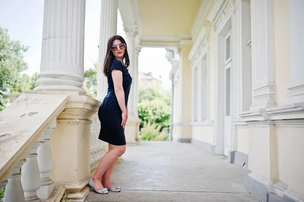 Brunett tjej på svart klänning, solglasögon poserade mot gamla vinta — Stockfoto