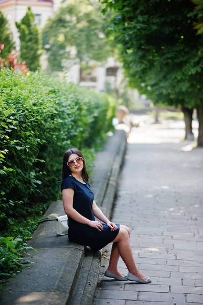 Morena menina de negócios em vestido preto em óculos de sol sentado em b — Fotografia de Stock