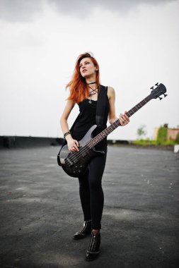 Kırmızı saçlı punk kız giyim siyah ile çatı, bas gitar.