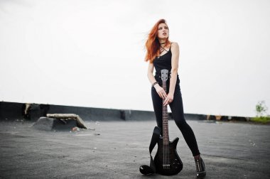 Kırmızı saçlı punk kız giyim siyah ile çatı, bas gitar.