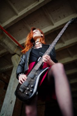 Bas guit ile siyah ve kırmızı etek giymek kırmızı saçlı punk kız