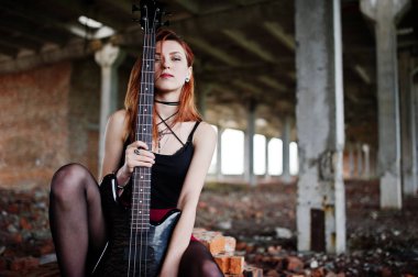 Bas guit ile siyah ve kırmızı etek giymek kırmızı saçlı punk kız