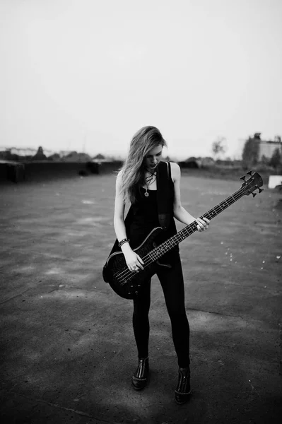 Rojo chica punk pelo desgaste en negro con bajo guitarra en el techo . —  Fotos de Stock