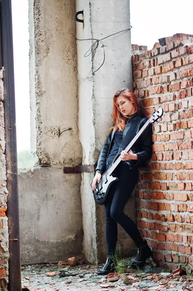 Rudowłosy dziewczyna punk zużycie na czarnym tle z gitara basowa w abadoned — Zdjęcie stockowe